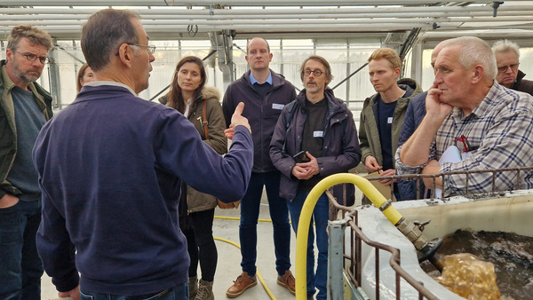 Ein Halbkreis von Menschen während einer Präsentation.